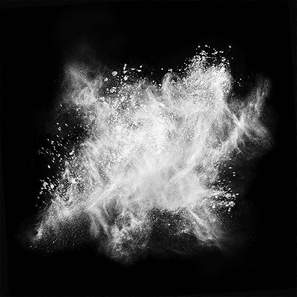 Black background with white fumed silica dust in the air