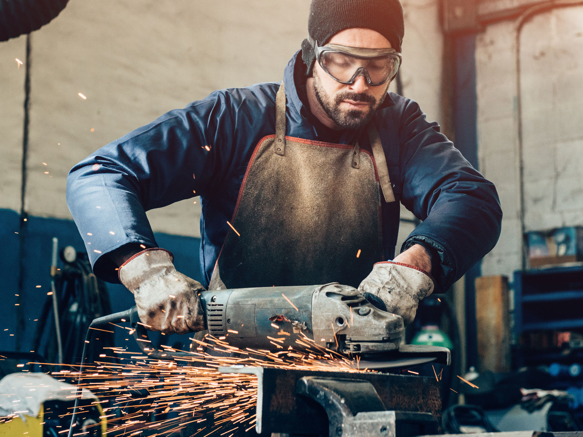 Man grinding metal in an area without dust or debris in the air, because solutions for fabrication dust collection are in use