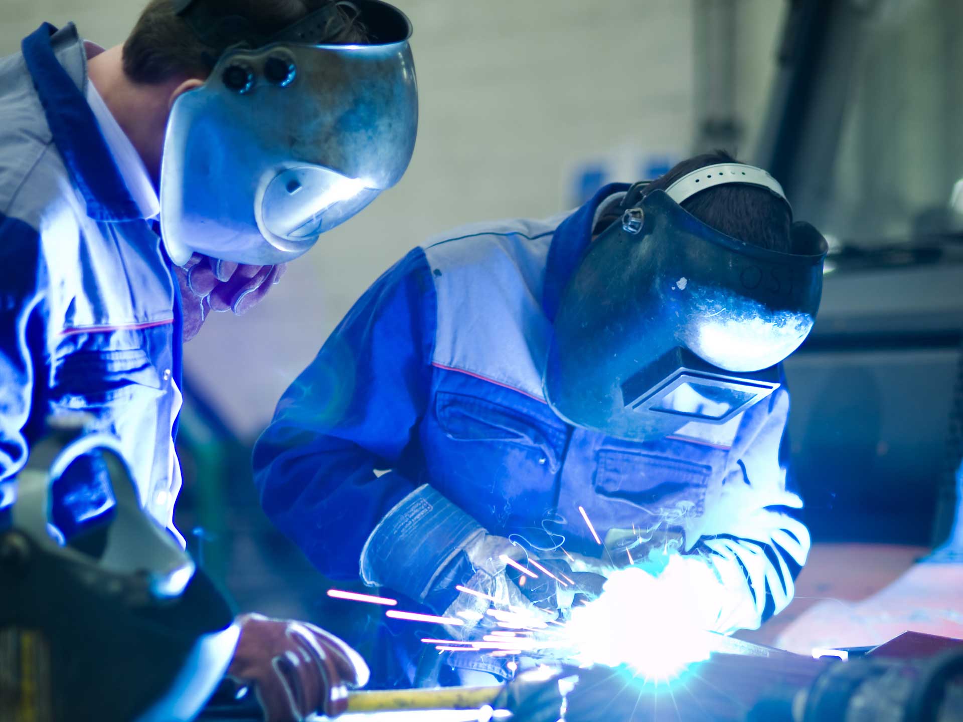 Student and teacher welding with no dust particles, due to fume collection system for welding schools