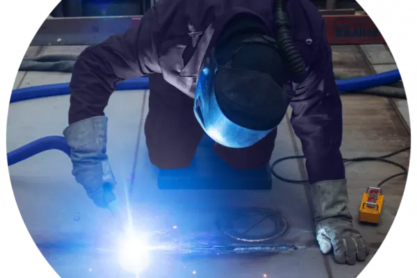 Man welding on the floor with no dust flying promoting solutions for dust collection for transportation equipment