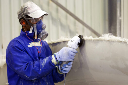 Man grinding fiberglass safely, since plastic and FRP dust collection solutions are in place