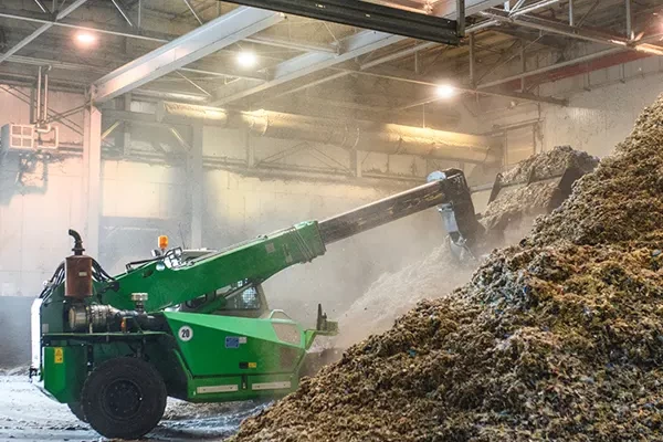 Heavy equipment working in a recycling plant in need of dust collection solutions.