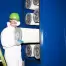 Man in white with mask and green hat replacing a filter for dust collector.