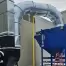 A blue Senturion dust collector from RoboVent installed outside an industrial facility.