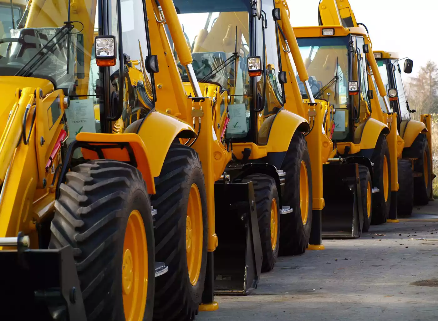 A line of new, bright yellow construction equipment or excavators.