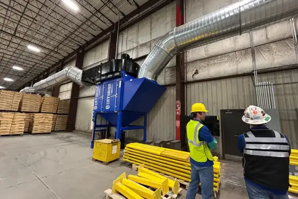 Technicians inspect dust collection equipment and ductwork during an on-site facility testing and evaluation visit.