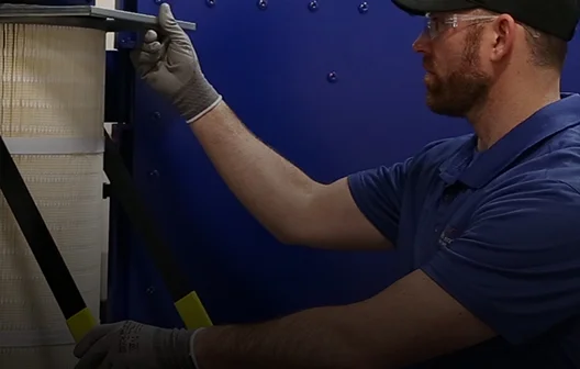 RoboVent employee servicing an industrial air filter as preventative maintenance