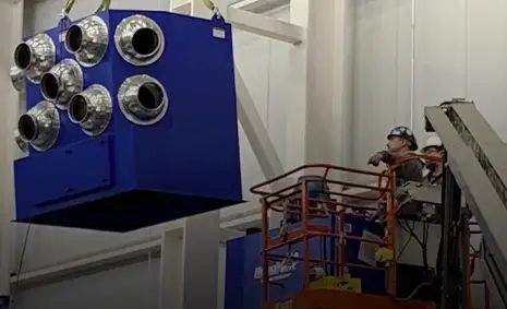 A RoboVent Industrial Dust Collector being lowered in a factory to be installed