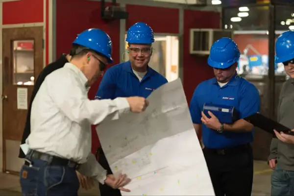 RoboVent specialists review facility drawings and system data as part of an industrial dust collection system audit.