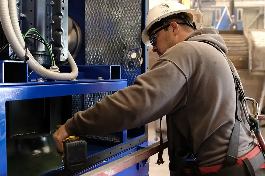 RoboVent technician repair work RoboVent technician performs hands-on dust collector repair work inside a blue industrial dust collector.
