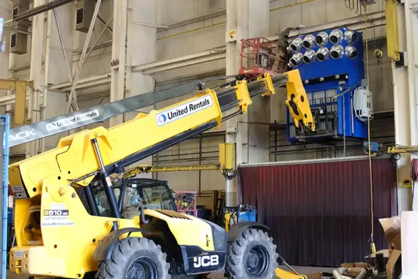 Technicians use lift equipment to build and install an industrial dust collection system.